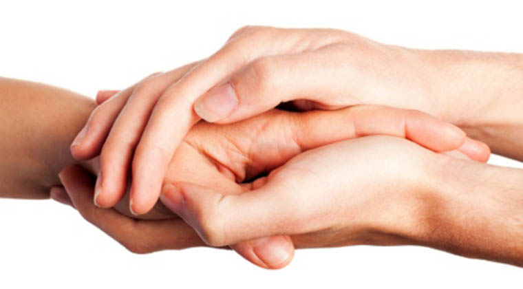Picture of hands of two people stacked over each other