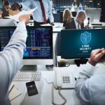 2 cyber security professionals sitting in front of computers
