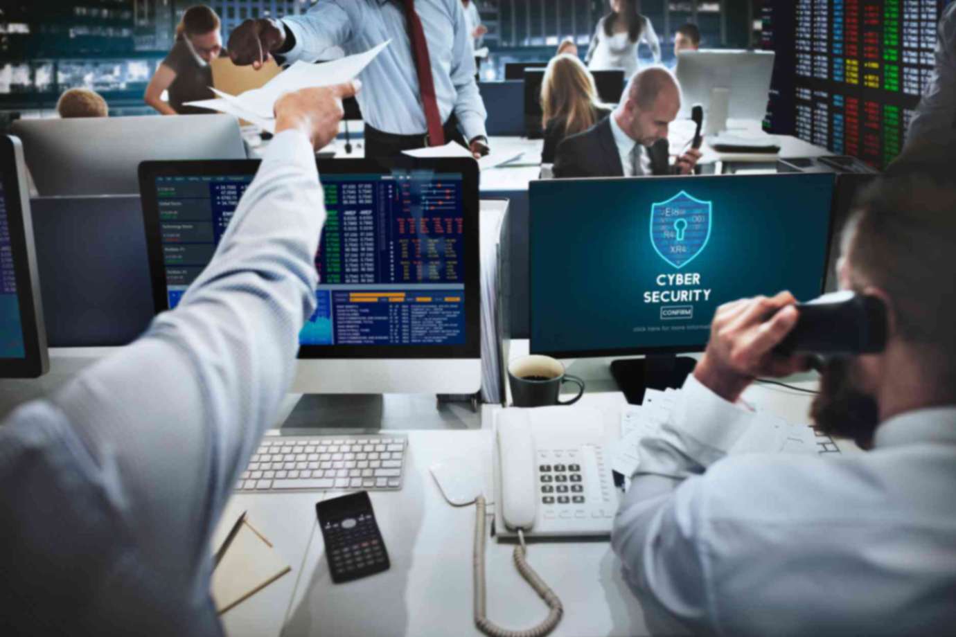 2 cyber security professionals sitting in front of computers