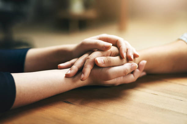 Closeup shot of two unidentifiable people holding hands in comfort
