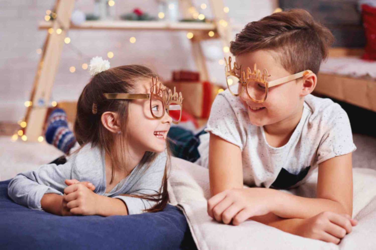 Brother and sister talking with each other, while lying in their playroom