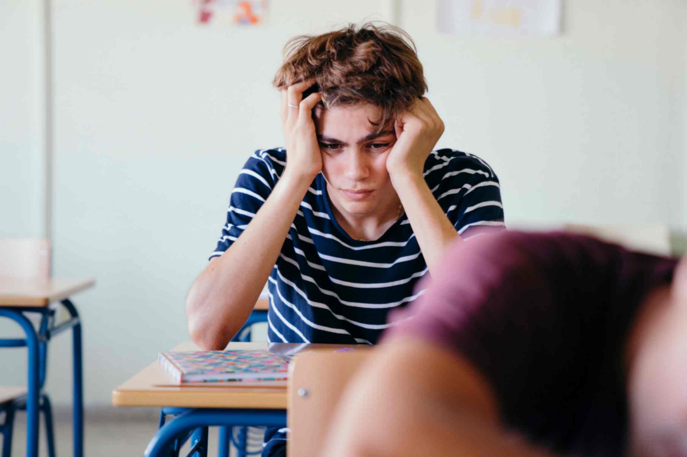 teen find it challenging to concentrate in a noisy classroom 