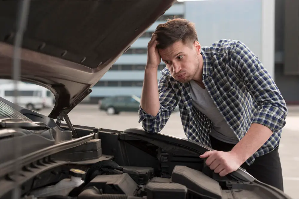 worried man standing by malfunctioned car