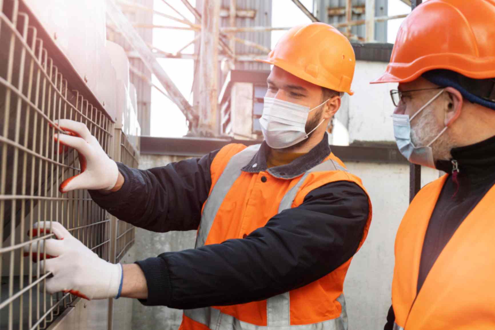 2 civil engineers with their masks on working in industry