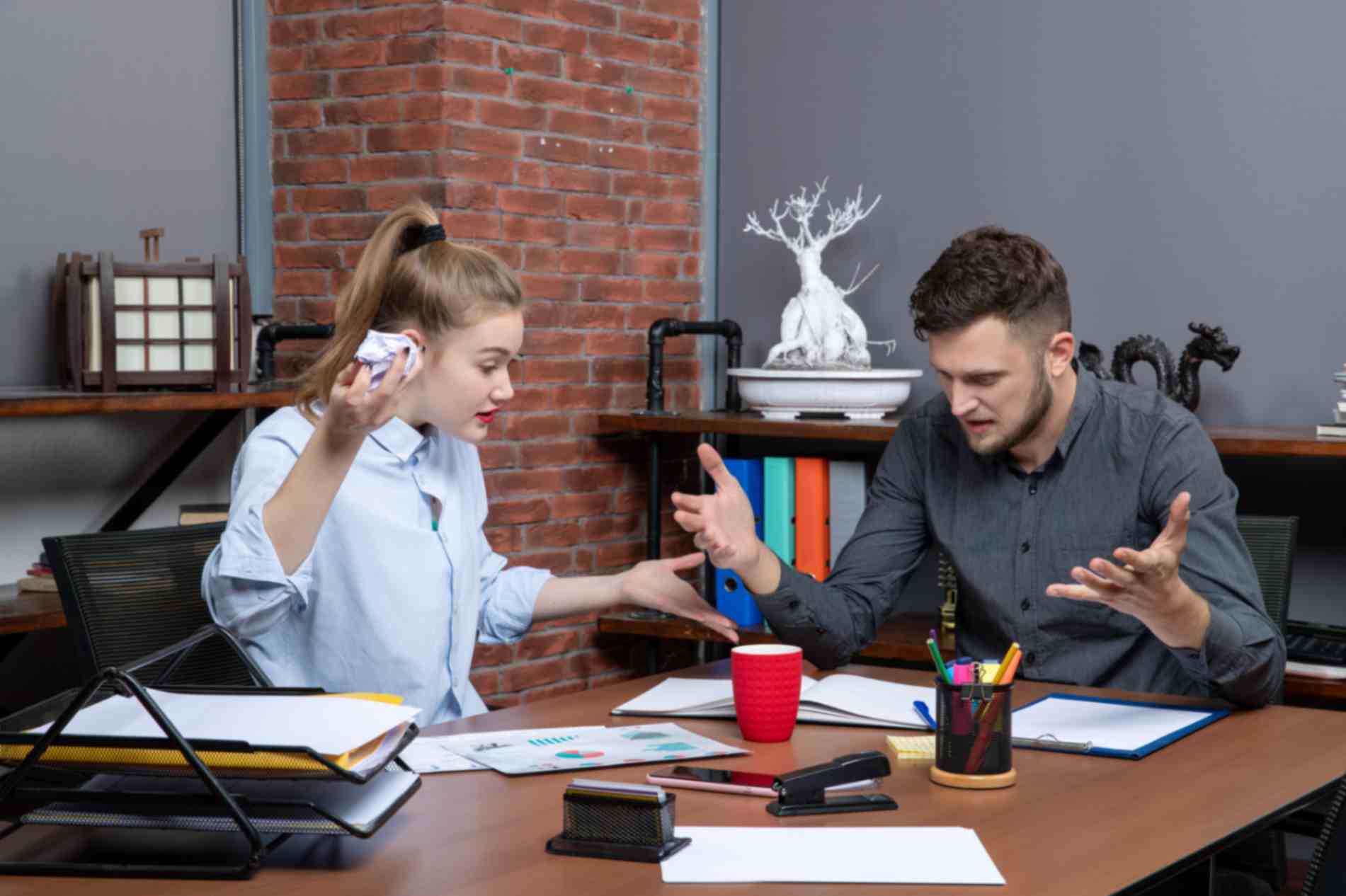 A man and woman arguing sitting in office