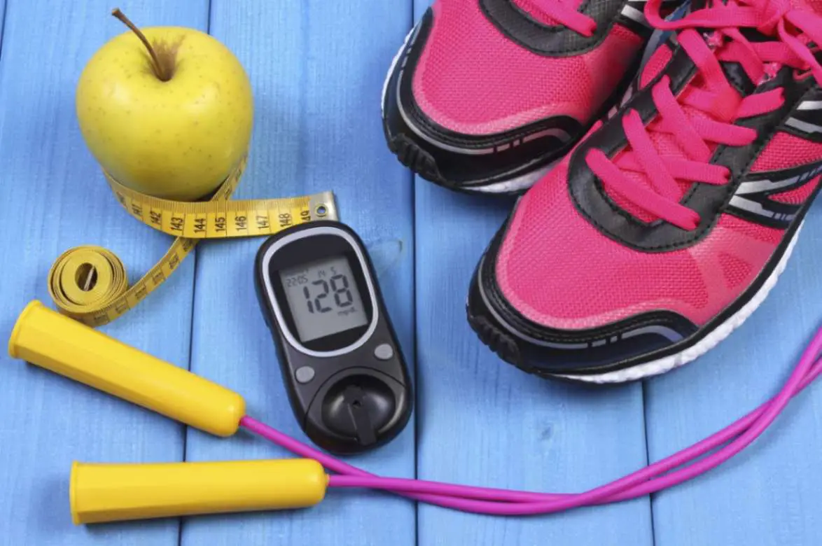 A picture of Apple, joggers, glucometer and rope placed on a table