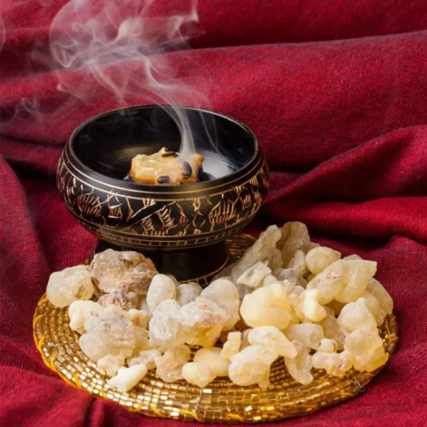 Frankincense burning in a pot and left over frankincense placed near the pot 