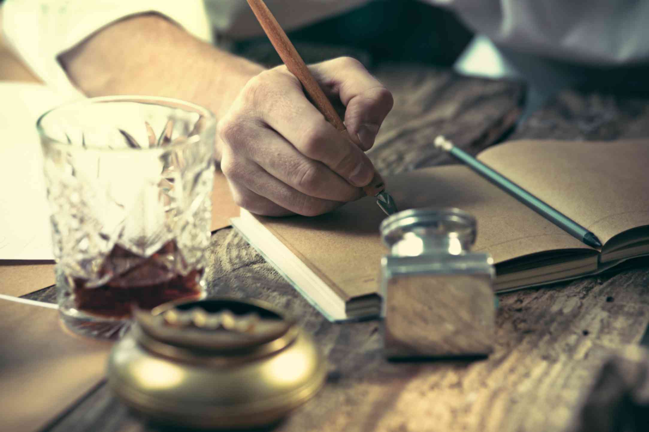 Young writer sitting on table doing calligraphy on sketchpad