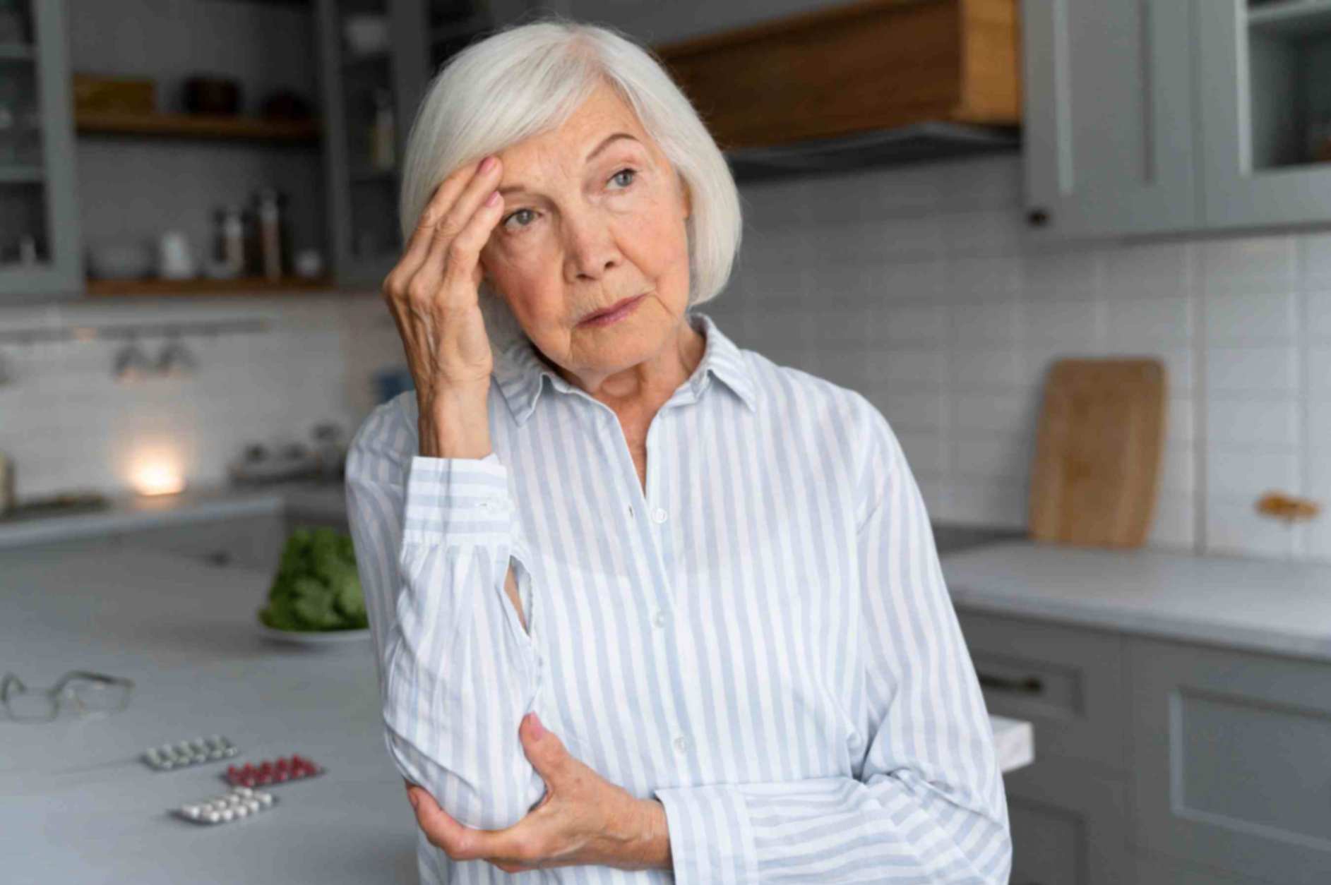 Elderly woman suffering from alzheimer sitting on chair immersed in her thoughts