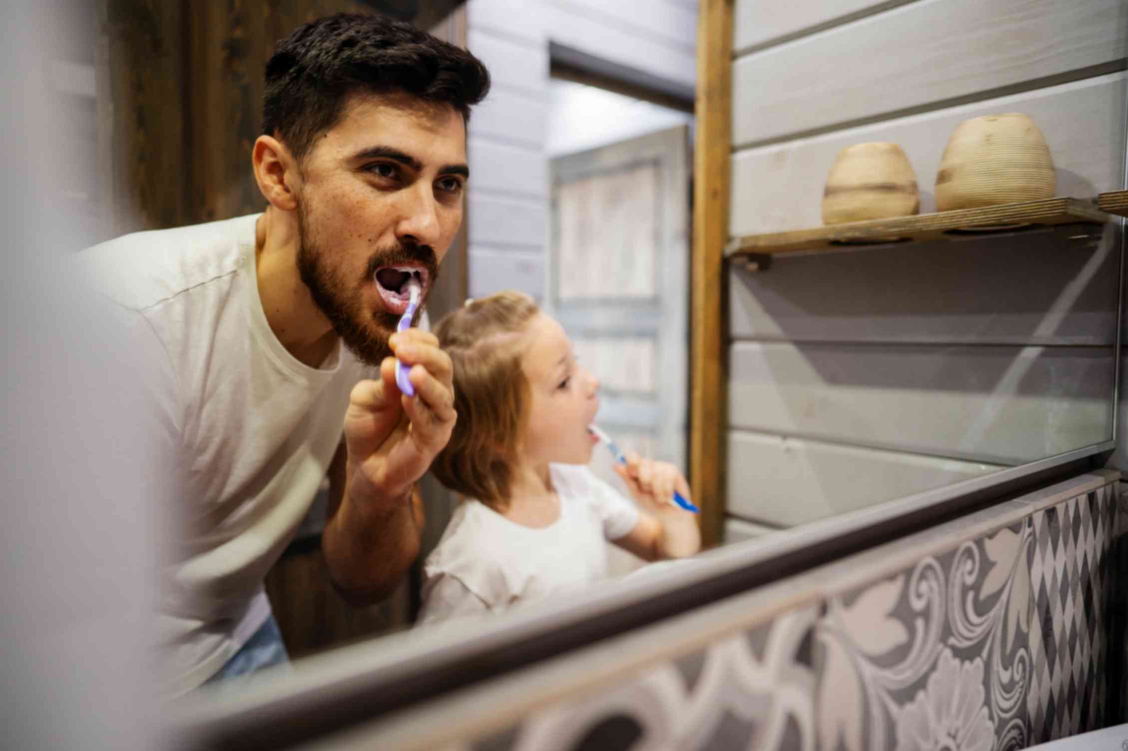 Father and Daughter Brushing Teeth Together