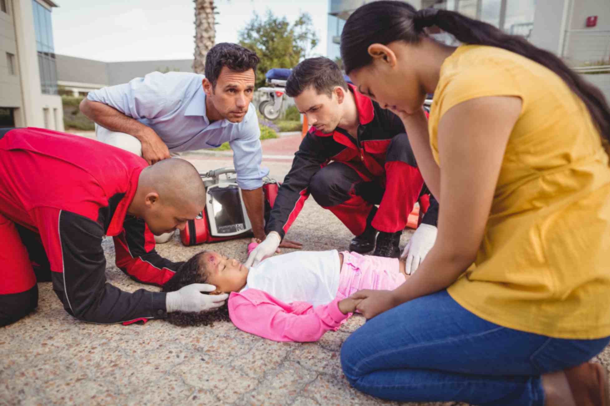 Paramedic staff giving first aid to a little girl