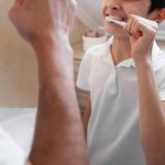 Kid is Brushing His Teeth With His Father