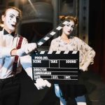 Male mime artist holding clapper front female mime artist