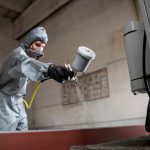 Man Spraying Soda Blast on the Metal
