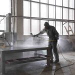 Man spraying powder paint from gun