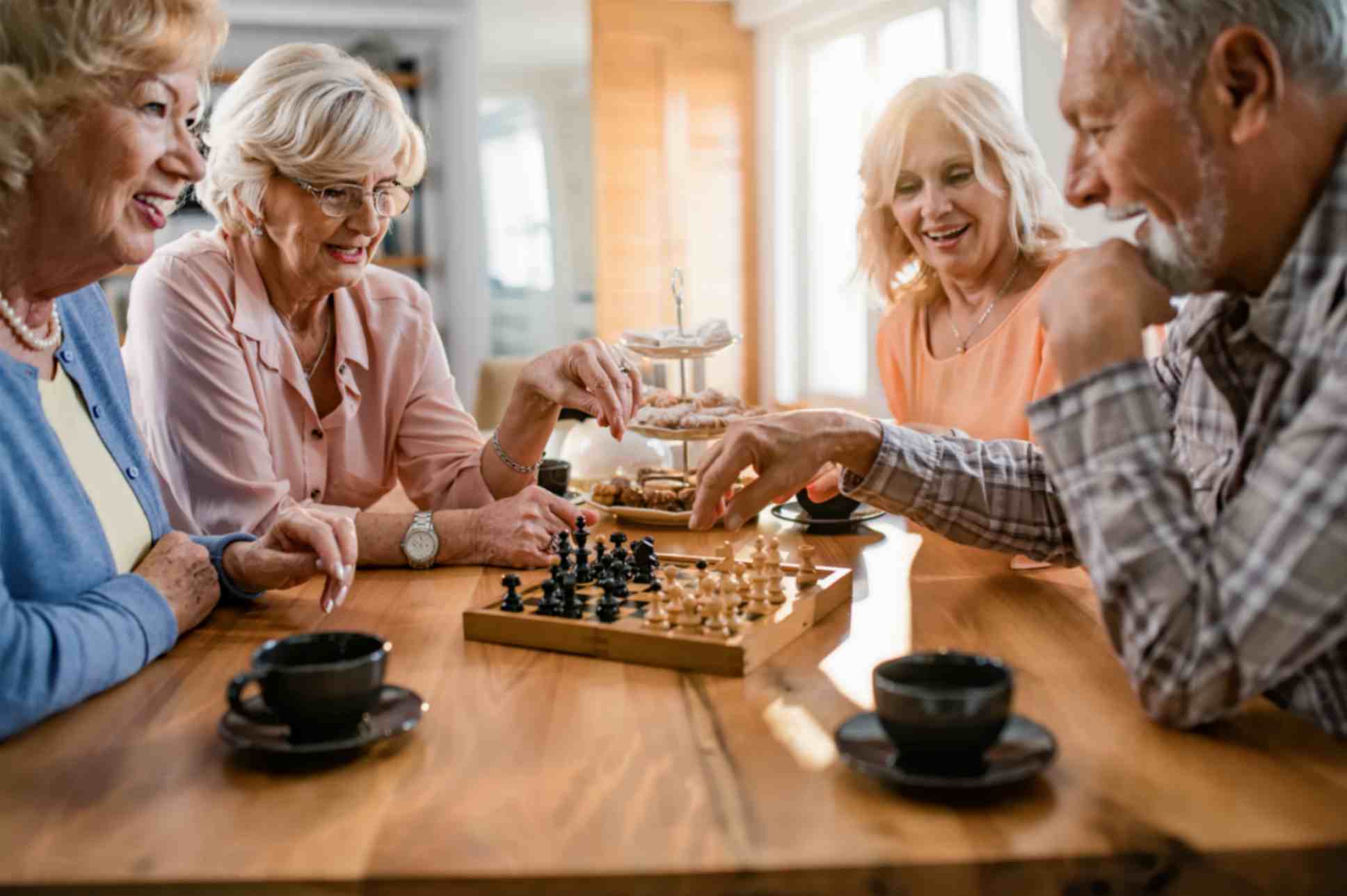 Mature Friends Enjoying While Playing Chess