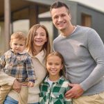 Parents with their kids posing for a photo outside their home - family portrait