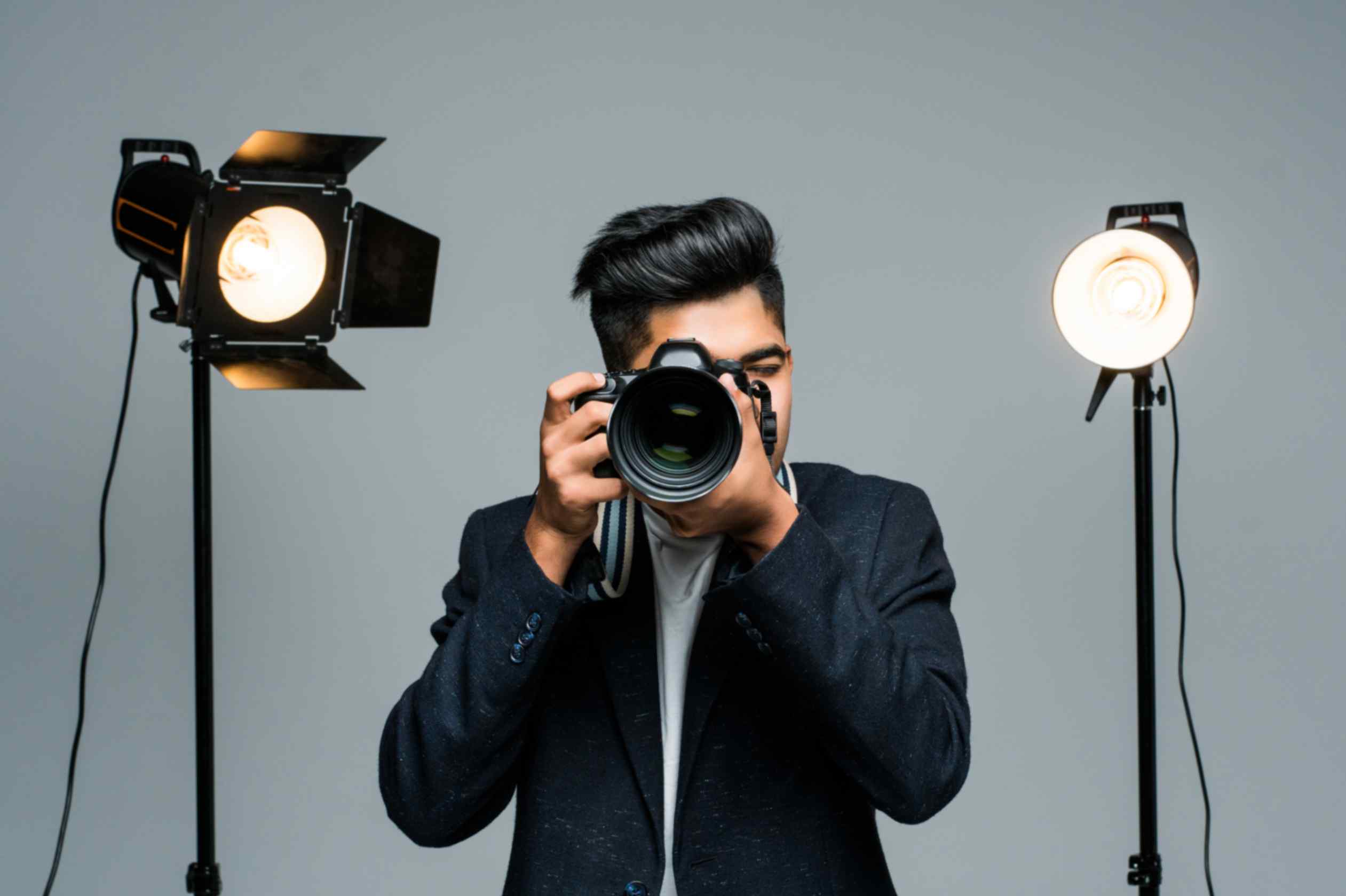Professional young photographer making videos in studio with light