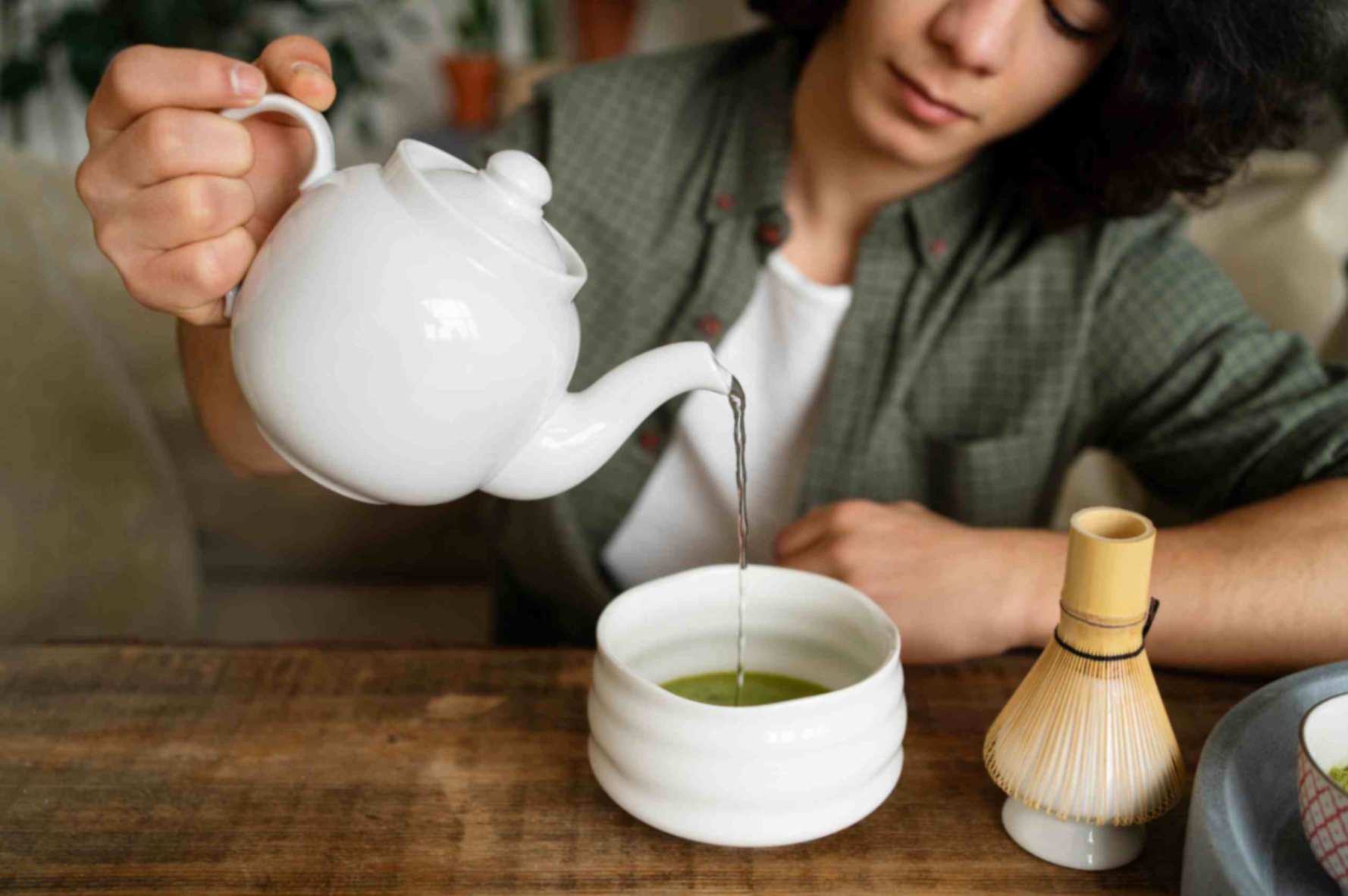 Woman pouring green tea into the cup..