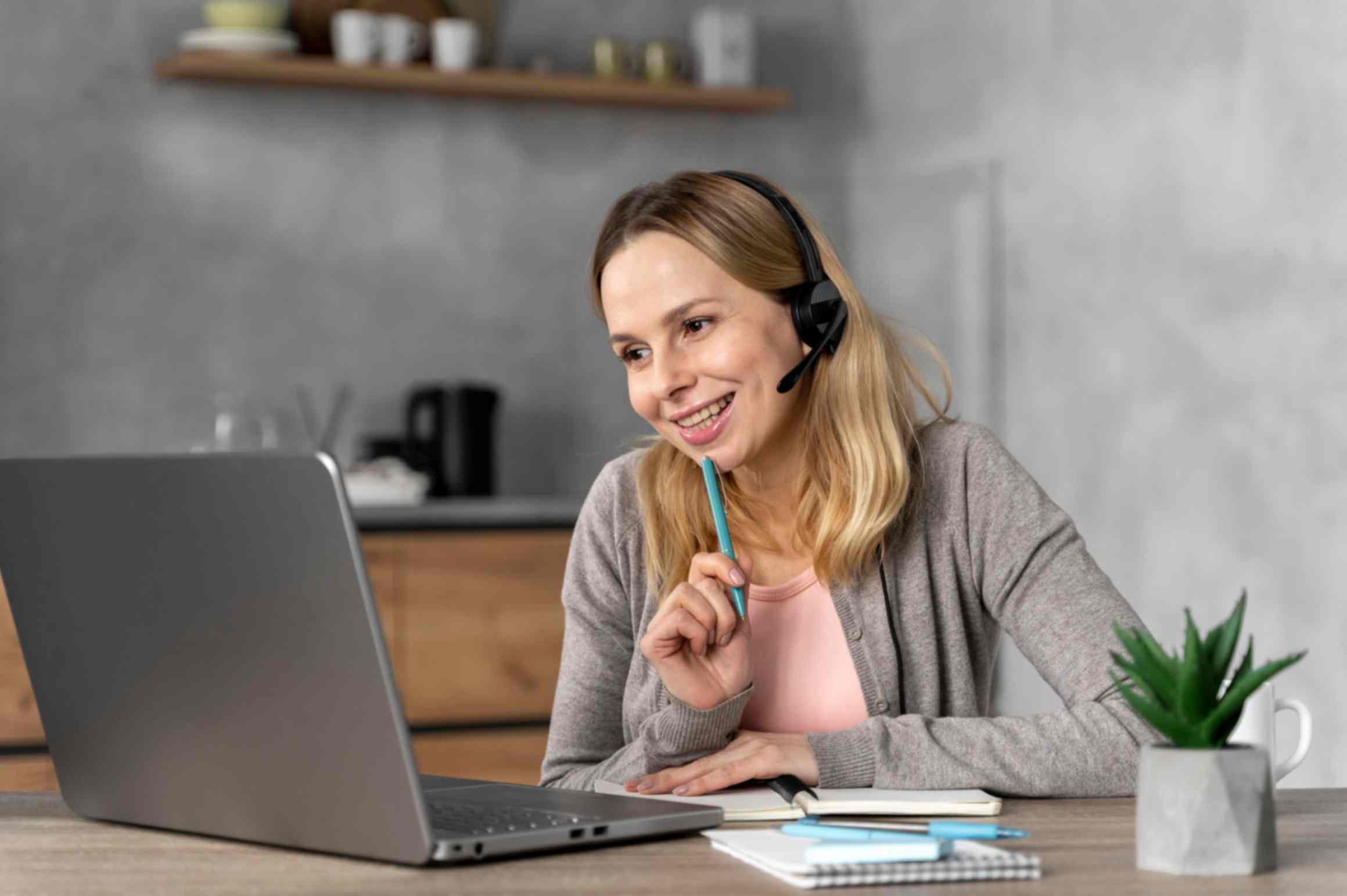 Woman with headset working on laptop