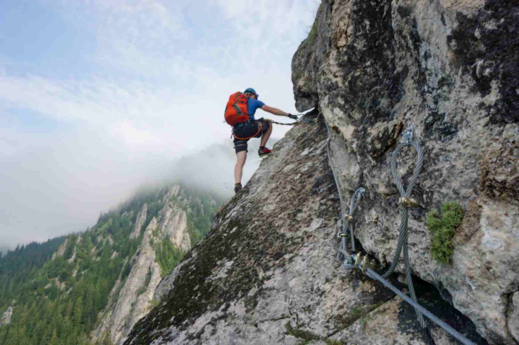 Young Man Climbing Up Cliff