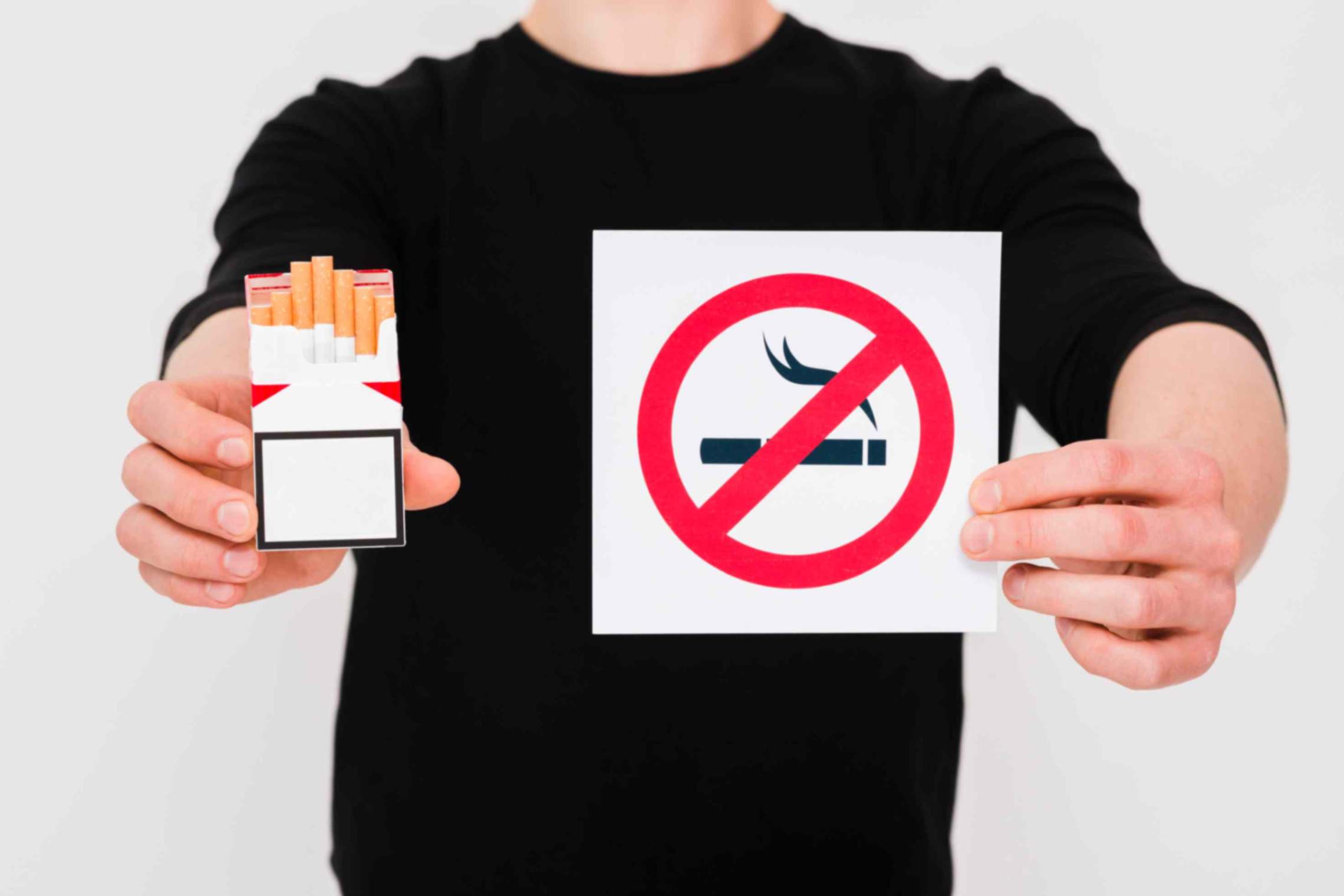 man holding cigarettes packet no smoking-sign over white background