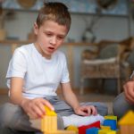 Mother playing with her autistic son using toys