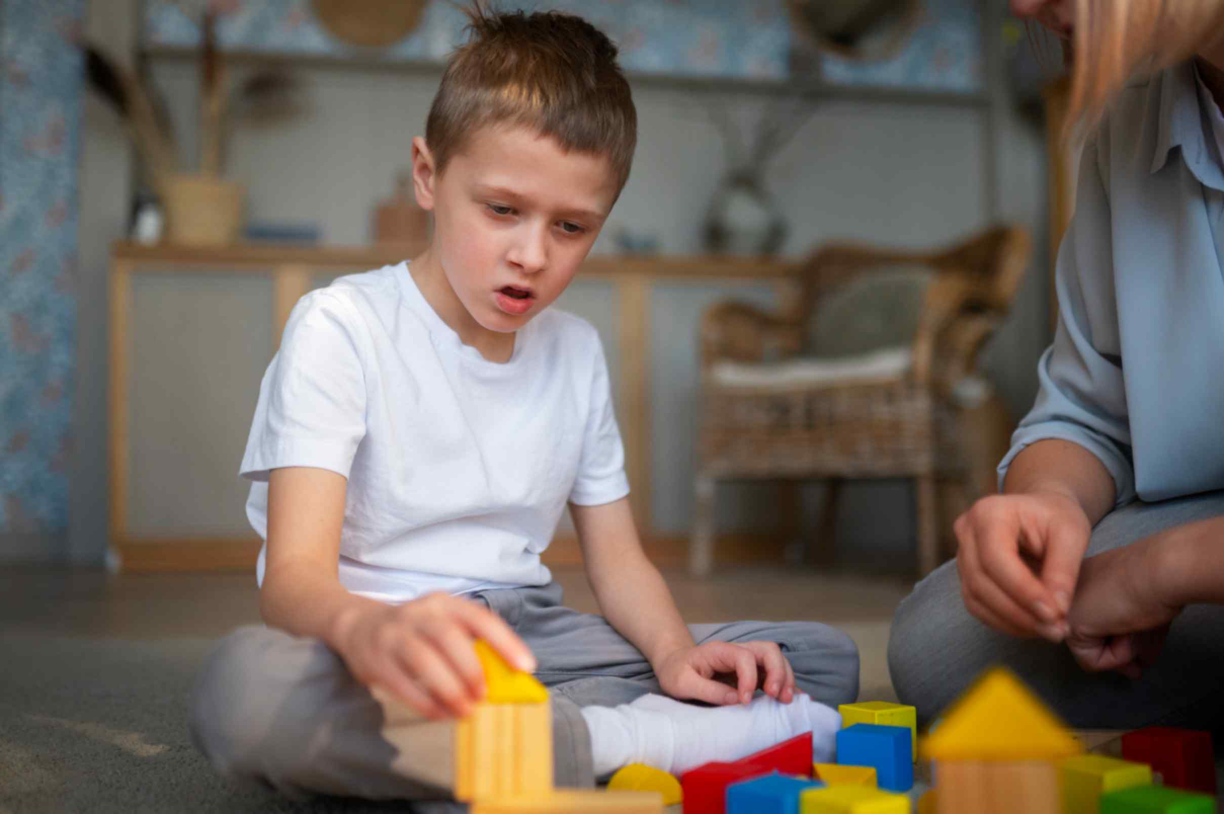 Mother playing with her autistic son using toys